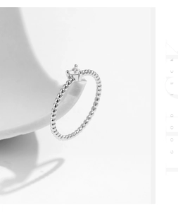 Détail d'une bague perlée en argent avec une moissanite sertie à quatre griffes en gros plan