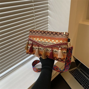 Close-up of Bohemian woven crossbody bag with colorful tassels and jacquard strap details