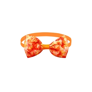 Detail view of pet bow tie featuring maple leaf patterns with orange elastic strap