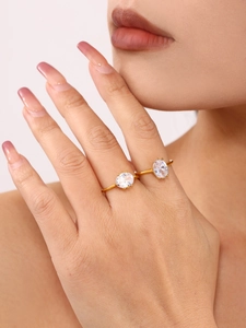 Close-up of elegant gold-plated rings with oval cubic zirconia on female model fingers