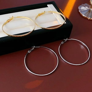 Detailed view of gold and silver plated hoop earrings with fine textured finish