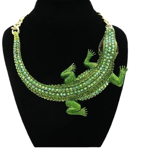 Vintage gold statement necklace with a large green rhinestone crocodile pendant on a model