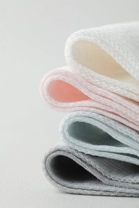 Detailed texture of stacked ultra-thin silk mesh socks in white, pink, blue, and grey