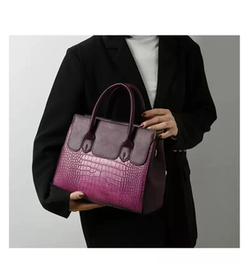 Detail of the gradient purple crocodile embossed leather on a luxury handbag