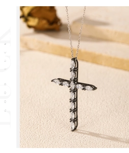 Detail of cross pendant with marquise-cut white zircons on black gold finish metal