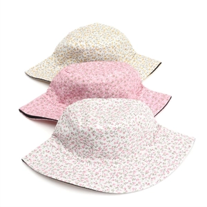 Detailed display of three reversible sun hats with various floral prints and patterns
