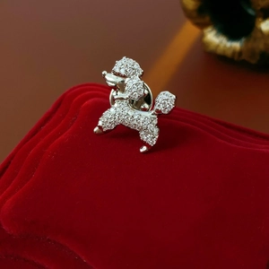 Macro view of silver poodle brooch with sparkling cubic zirconia on red velvet box