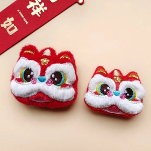 Dettaglio macro di due teste di danza del leone in peluche rosso con ricami e pelliccia