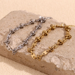 Minimalist 14K gold and silver stainless steel coffee bean knot anklet on stone surface