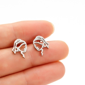 Close-up of abstract face silhouette earrings held by hand for size reference