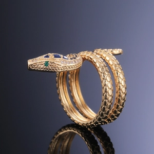 Primer plano de un anillo de serpiente dorado con piedra azul y textura de escamas