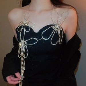 Close-up of sparkling rhinestone flower body chain with tassels on a black outfit