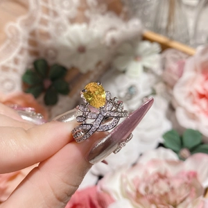 Detail of silver crown ring with yellow pear-cut gemstone and pavé diamonds