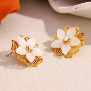 Makroaufnahme von 18K Gold Muschelblumen Ohrringen mit Perle und filigranen Metalldetails