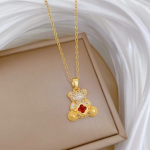 Detail of gold teddy bear pendant with red crystal and cubic zirconia on jewelry box