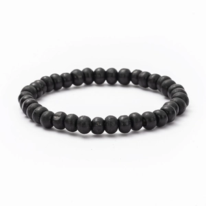 Macro detail of matte black wooden beads on a minimalist diy retro braided bracelet