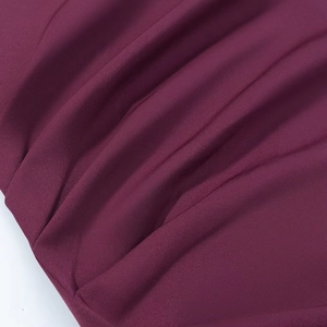 Gros plan sur la texture du tissu rouge vin avec des plis détaillés et fins