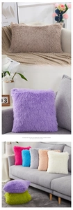 Detail of plush faux fur cushion covers in various colors and sizes for sofa decor