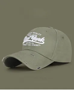Detail of 3D letter embroidery and vintage distressed brim on olive canvas baseball cap