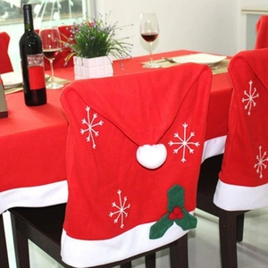 Red Christmas hat chair covers with snowflake embroidery and white pom-poms for table decor