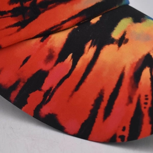 Detail of twill fabric ponytail baseball cap with vibrant orange and blue tie-dye pattern