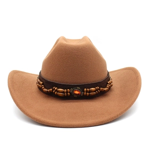 Détail d'un chapeau de cowboy en feutre marron avec perles ethniques et pierre rouge