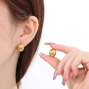 18K gold plated titanium teardrop earrings with star pattern and crystals on model