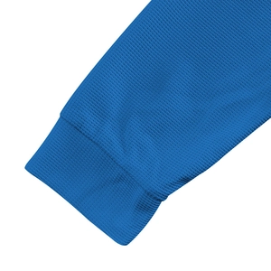 Detailed close-up of blue waffle knit texture and ribbed cuff on men's long sleeve henley