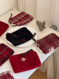 Detail view of red plaid wool wallets with bow embroidery and zipper closure
