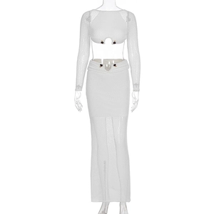 Detail of white long sleeve crop top and long skirt with decorative black ball buttons