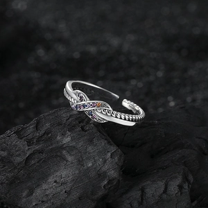 Elegant S925 sterling silver twisted knot ring with colorful zircon stones on rock background