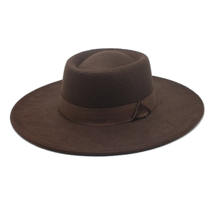 Detailed view of dark brown wool felt boater hat with matching ribbon and flat top design