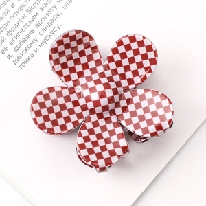 Detail view of flower-shaped hair claw clip with a red and white checkered pattern