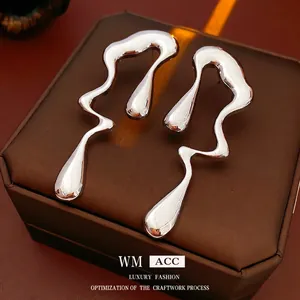 Boucles d'oreilles irrégulières en métal liquide argenté sur une boîte à bijoux