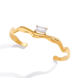 Golden wavy stainless steel open cuff bracelet with a rectangular zircon stone