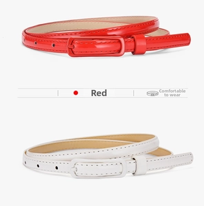 Close-up of slim red and white glossy patent leather belts with matching square buckles