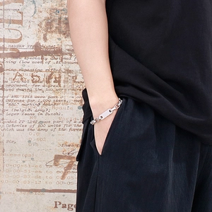 Close-up of vintage stainless steel chain bracelet with a polished rectangular plate on wrist
