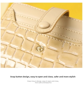 Close-up of cream crocodile pattern leather wallet featuring a secure metal snap closure