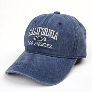 Detailed close-up of white 3D embroidery on a navy washed cotton vintage baseball cap