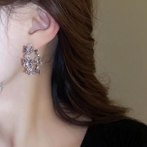 Detail of silver butterfly C-shaped hoop earring with sparkling zircon inlay on the ear