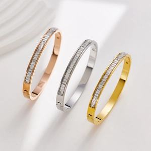 Detailed close-up of zircon-inlaid bangles in rose gold, silver, and gold finishes
