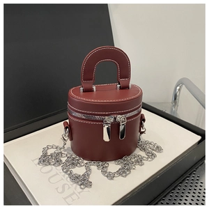 Vue détaillée du sac seau bordeaux avec surpiqûres blanches et accessoires argentés