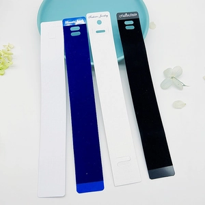 Dettaglio dei cartoncini per gioielli in PVC bianco e nero con fori per esposizione appesa