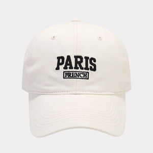 Detailed close-up of embroidered PARIS lettering on the off-white cotton baseball cap