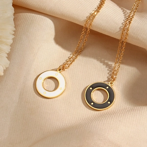 Detail of black and white sunburst pendants on champagne satin background with gold chains