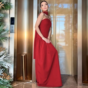 Detail view of a long red strapless evening gown with matching neck scarf accessory
