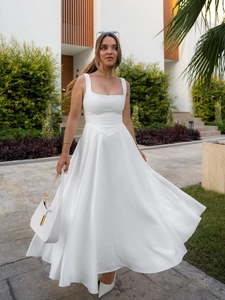 Elegant white square neck sleeveless maxi dress with flared hem for a chic vacation look