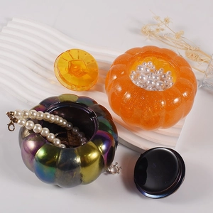 Iridescent and glitter pumpkin resin jars for jewelry storage with pearl necklaces