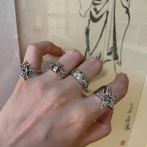 Dettaglio macro di anelli a stella retrò in argento sulla mano con stelle intagliate