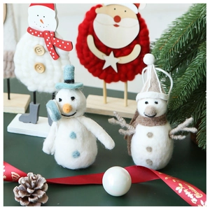 Détail d'ornements faits main en feutre de laine avec bonhomme de neige et socle bois